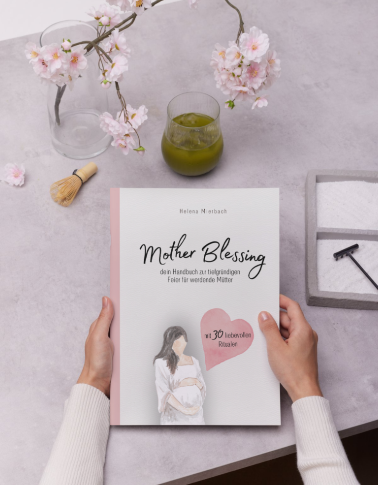 Buch "Mother Blessing" gehalten von zwei Händen über grauer Tischplatte